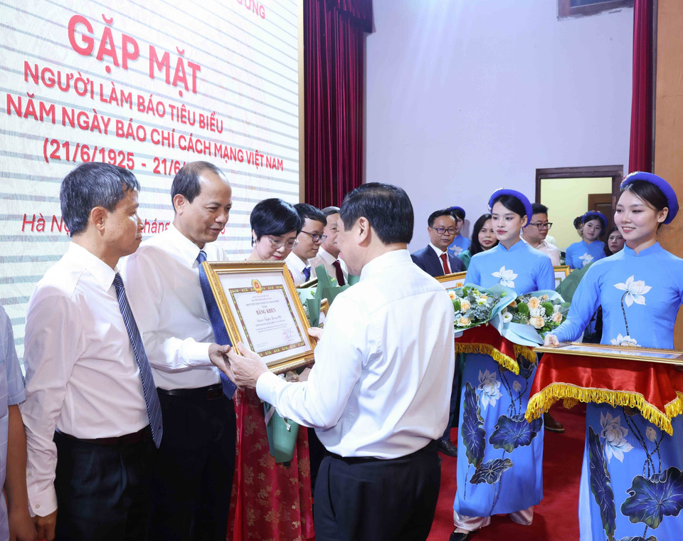 Đồng chí Lại Xuân Môn, Uỷ viên Trung ương Đảng, Phó Trưởng Ban Thường trực Ban Tuyên giáo và Dân vận Trung ương trao Bằng khen cho nhà báo Nguyễn Quang Hải, Trưởng Ban Biên tập Ảnh TTXVN (Ảnh: Phương Hoa/TTXVN)