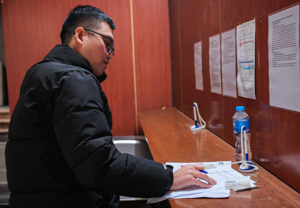 Người dân hoàn thiện hồ sơ cấp, đổi giấy phép lái xe khi lấy được số thứ tự sáng 25/2. (Ảnh: Hoàng Hiếu/TTXVN)