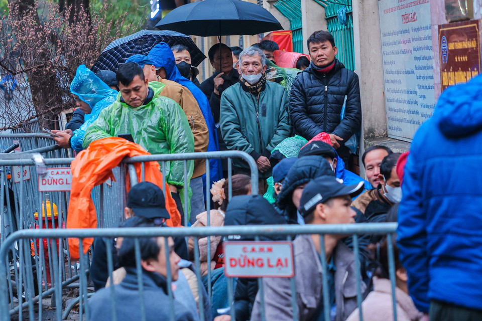 Dù thời tiết ngoài trời chỉ khoảng 16 độ C, nhưng nhiều người dân vẫn đến sớm chờ đợi làm thủ tục cấp, đổi giấy phép lái xe. (Ảnh: Hoàng Hiếu/TTXVN)