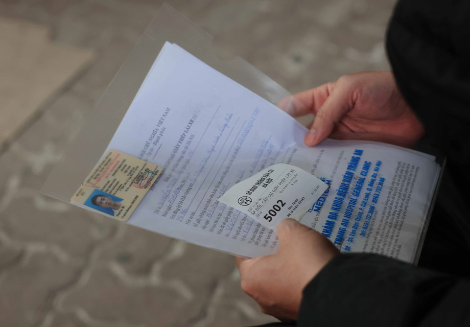 Một người dân lấy được số thứ tự để làm thủ tục cấp, đổi giấy phép lái xe tại Sở GTVT Hà Nội. (Ảnh: Hoàng Hiếu/TTXVN)