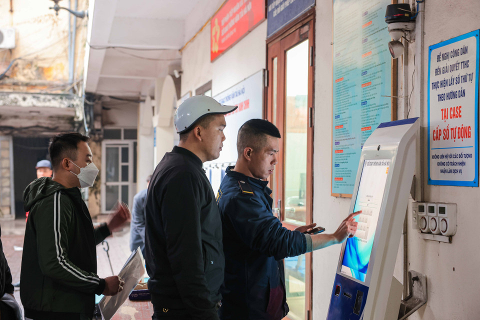 Người dân làm thủ tục để lấy số thứ tự làm thủ tục cấp, đổi giấy phép lái xe. (Ảnh: Hoàng Hiếu/TTXVN)