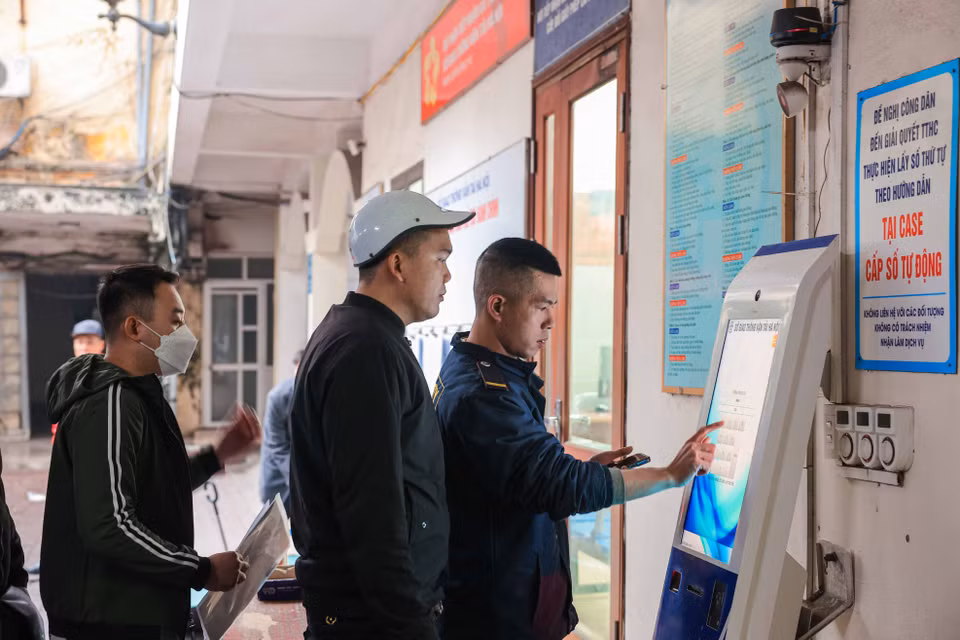 Người dân làm thủ tục để lấy số thứ tự làm thủ tục cấp, đổi giấy phép lái xe. (Ảnh: Hoàng Hiếu/TTXVN)