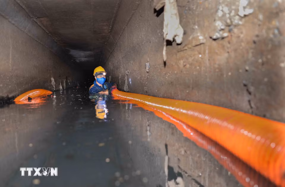 Xí nghiệp Thi công cơ giới xây lắp (Công ty Thoát nước Hà Nội) nạo vét tuyến cống Xuân Tảo (1,5x2m) bằng cơ giới kết hợp thủ công. Với 5 tổ thực hiện, công nhân trực tiếp xuống cống vận hành vòi hút, xử lý khoảng 1.000m³ bùn mỗi đợt, đảm bảo thoát nước mùa mưa. (Ảnh: Phan Phương/TTXVN)