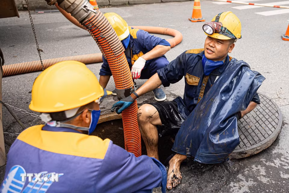 Kết thúc một ca làm thu gom rác dưới cống ngầm của các công nhân Công ty TNHH MTV Thoát nước Hà Nội. (Ảnh: Tiến Long/TTXVN phát)