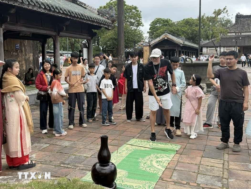 Du khách thích thú trò chơi gian dân tại Đại Nội Huế trong ngày mùng 1 Tết Bính Ngọ 2026. (Ảnh: Hải Âu/TTXVN)