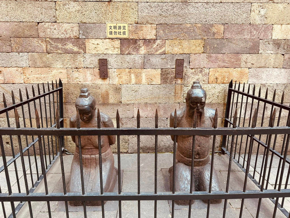 Tượng của vợ chồng Tần Cối quỳ gối trong hàng rào sắt ngàn năm bất động trước Miếu Nhạc Phi. (Ảnh: Anh Quang/Vietnam+)