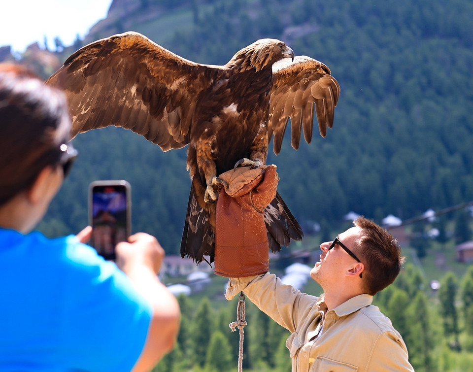 Du khách thích thú với những chú đại bàng khi tham quan Công viên quốc gia Terelj. (Ảnh: Thanh Tùng/TTXVN)