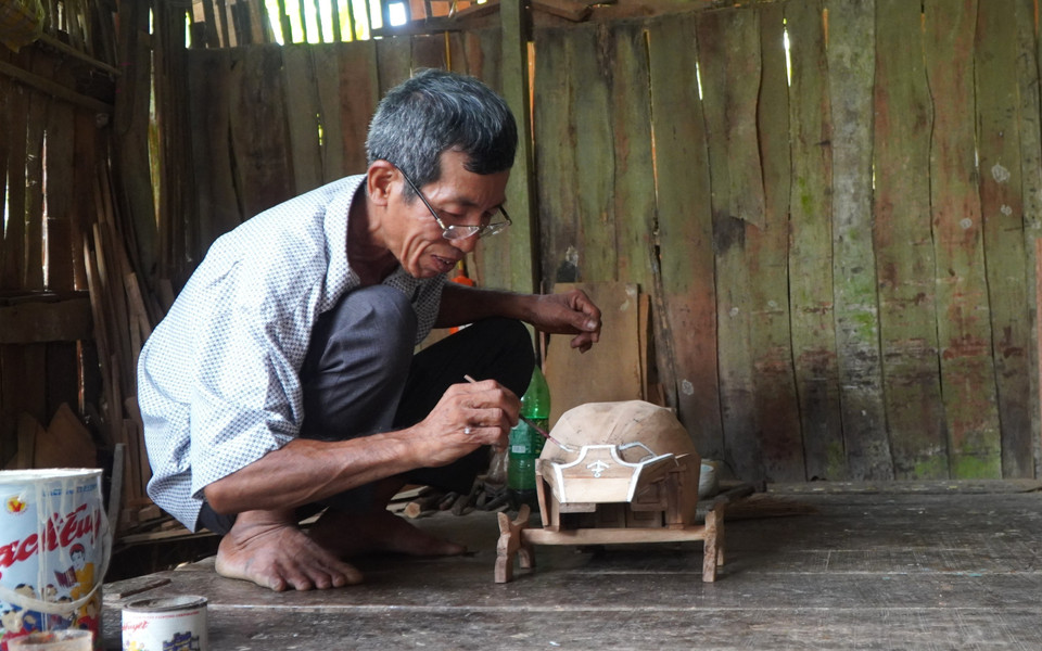Ông Nguyễn Văn Tốt làm sản phẩm xuồng, ghe mini. (Ảnh: Nhựt An/TTXVN)