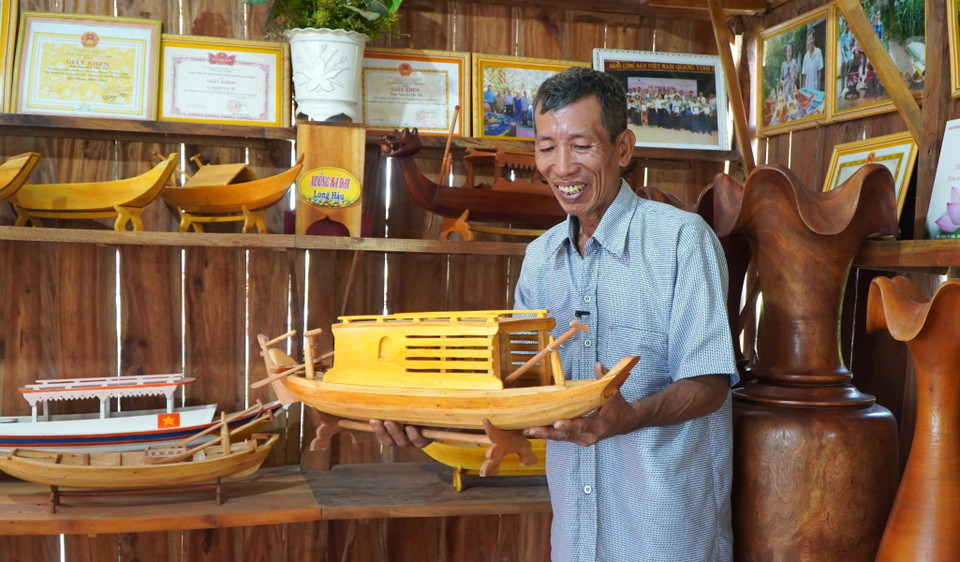 Ông Nguyễn Văn Tốt với sản phẩm xuồng, ghe mini. (Ảnh: Nhựt An/TTXVN)