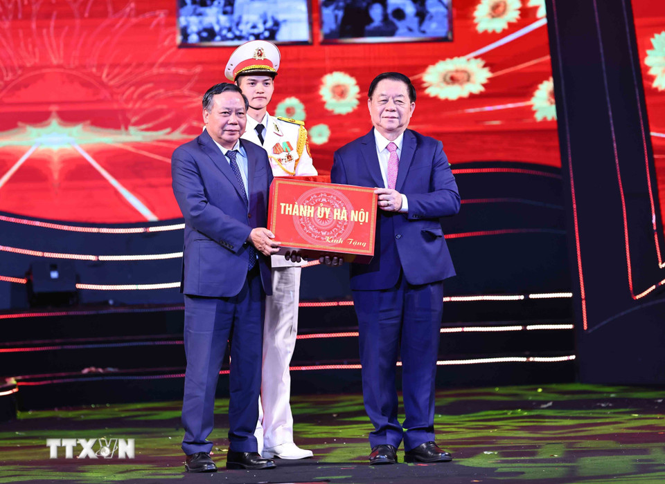 Trưởng Ban Tuyên giáo Trung ương Nguyễn Trọng Nghĩa tiếp nhận kỷ vật từ Phó Bí thư Thường trực Thành ủy Hà Nội Nguyễn Văn Phong. (Ảnh: Minh Đức/TTXVN)