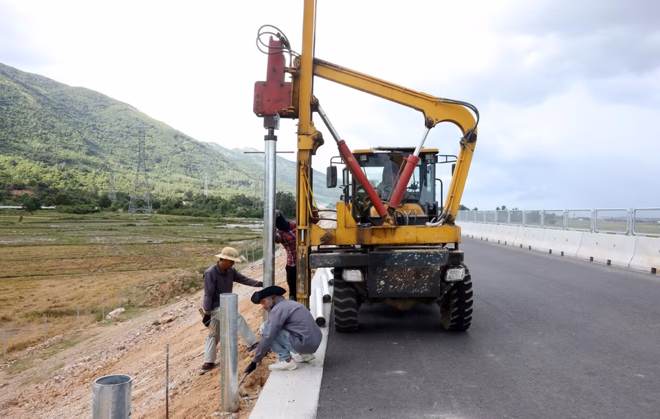 Thi công lắp đặt hệ thống tôn sóng hai bên đường ở những đoạn cuối cùng trên tuyến. (Ảnh: Quốc Khánh/TTXVN)