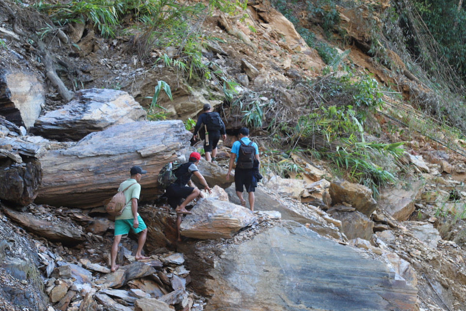 Người dân gặp nhiều khó khăn khi di chuyển qua các điểm sạt lở trên tuyến đường độc đạo vào bản. (Ảnh: Xuân Tiến/TTXVN)