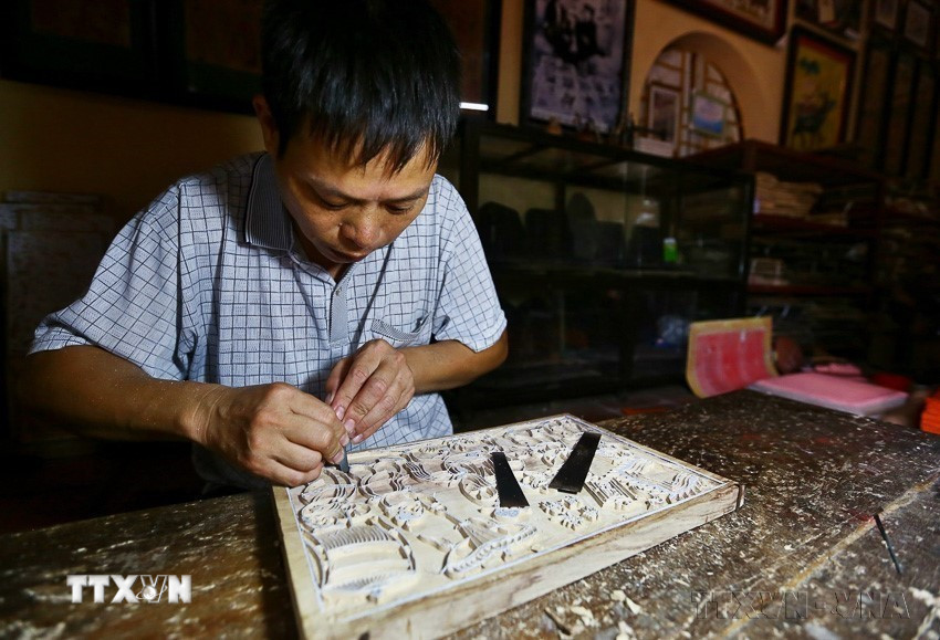 Sáng tác mẫu tranh và khắc ván là khâu sáng tạo quan trọng nhất của quy trình làm tranh Đông Hồ, quyết định sự sinh tồn của một làng tranh, đòi hỏi năng khiếu bẩm sinh và kỹ năng lao động cao ở các nghệ nhân. (Ảnh: Minh Quyết/TTXVN)