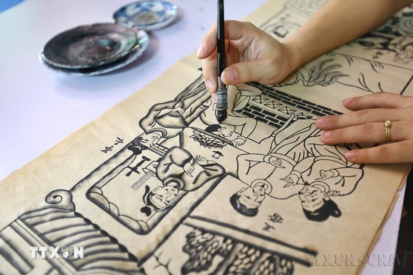 Công việc sáng tác mẫu tranh Đông Hồ tốn rất nhiều thời gian. Trước tiên phải lựa chọn đề tài, ý nghĩa, nội dung sâu sắc, màu sắc hài hoà, bố cục chặt chẽ và có giá trị nghệ thuật cao. (Ảnh: Minh Quyết/TTXVN)