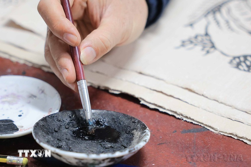 Mực màu trên tranh Đông Hồ đều được làm từ nhiên liệu tự nhiên, như màu vàng của hoa hòe, màu đỏ của hoa hiên, màu trắng từ bột vỏ sò, điệp và màu đen của than lá tre (2025). (Ảnh: Hoàng Hiếu/TTXVN)