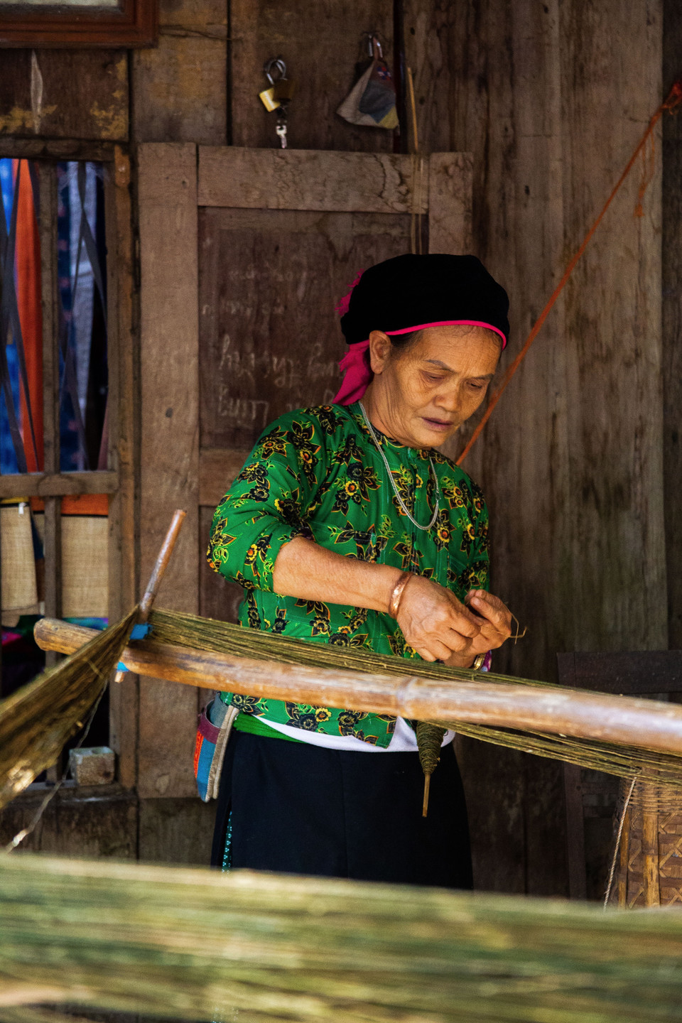 Bên khung cửi, phụ nữ Mông kiên trì với từng động tác móc sợi dọc quen thuộc. (Ảnh: Lan Anh/TTXVN phát)