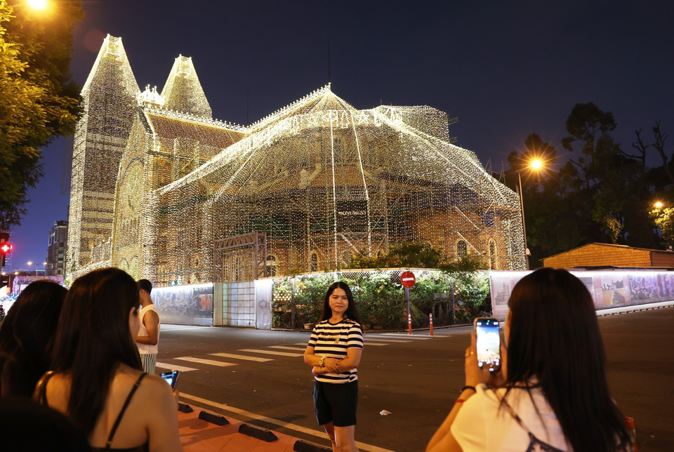 Khách du lịch check-in tại Nhà thờ Đức Bà Thành phố Hồ Chí Minh. (Ảnh: Hồng Đạt/TTXVN)