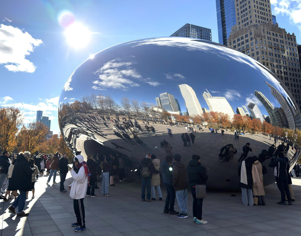 Sự hòa quyện giữa thiên nhiên và kiến trúc đô thị phản chiếu trên bề mặt Cloud Gate. (Ảnh: Ngọc Quang/TTXVN)