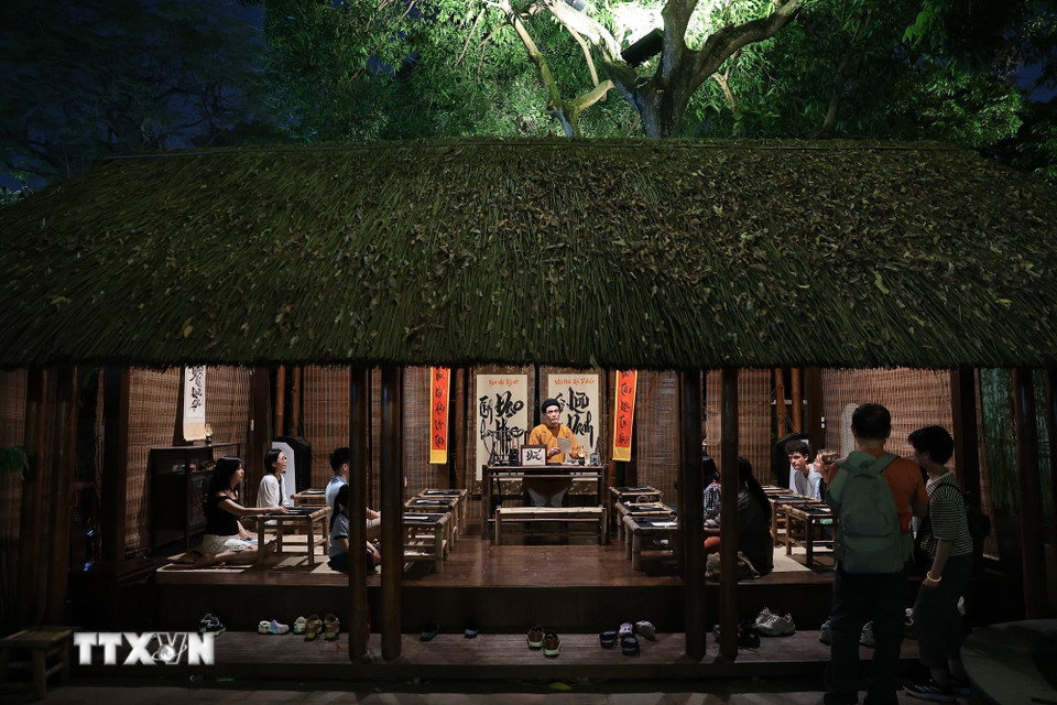 Không gian lớp học xưa được tái hiện tại Văn Miếu, nơi hoạt động thư pháp trở thành cầu nối giữa di sản Nho học và trải nghiệm đương đại. (Ảnh: Phạm Tuấn Anh/TTXVN)