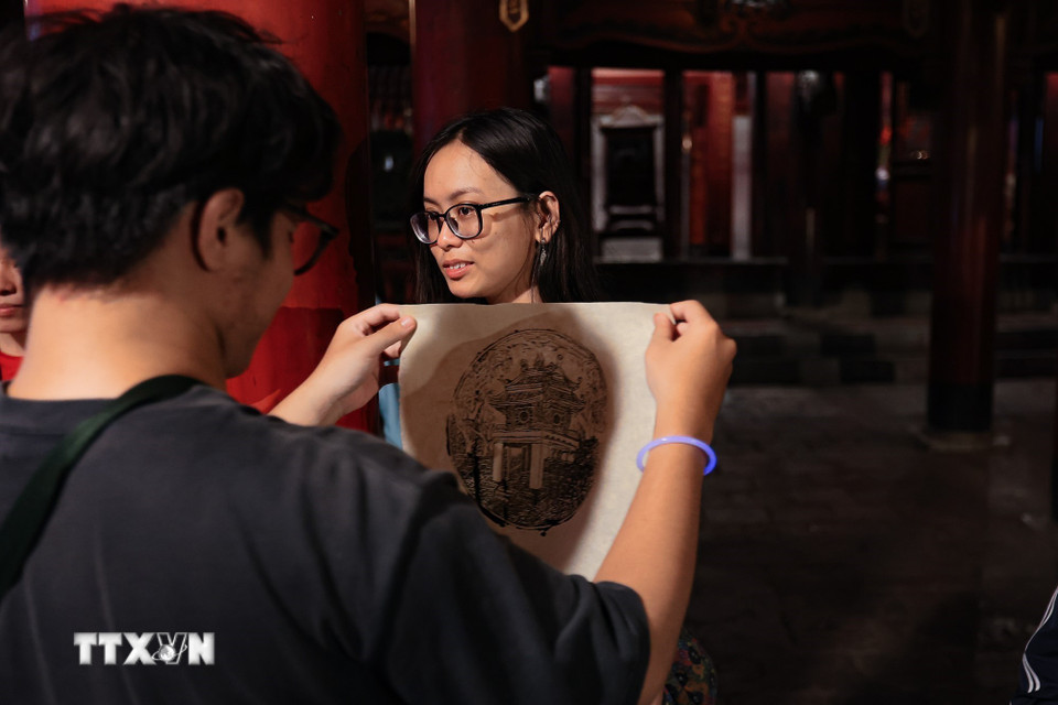 Du khách trải nghiệm in tại Văn Miếu – Quốc Tử Giám. (Ảnh: Phạm Tuấn Anh/TTXVN)