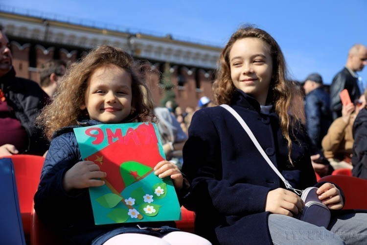 Thiếu nhi Nga mang theo bức tranh về ngày Chiến thắng tại Lễ duyệt binh kỷ niệm 77 năm Chiến thắng phátxít (1945 - 2022), trên quảng trường Đỏ (Nga, 9/5/2022). (Ảnh: Trần Hiếu/TTXVN)