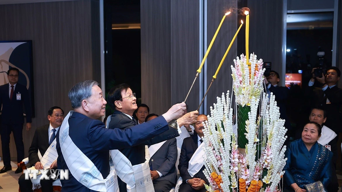 Tổng Bí thư Tô Lâm cùng Tổng Bí thư, Chủ tịch nước Lào Thongloun Sisoulith thực hiện nghi lễ buộc chỉ cổ tay truyền thống của Lào. (Ảnh: Dương Giang/TTXVN)