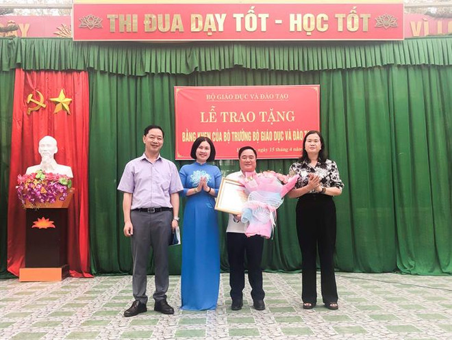 Phó Chủ tịch Công đoàn Giáo dục Việt Nam Lê Thị Mai Oanh trao Bằng khen của Bộ trưởng Bộ GDĐT cho thầy giáo Đào Thanh Hương. (Ảnh: Bộ GD-ĐT) bang khen 2.jpeg