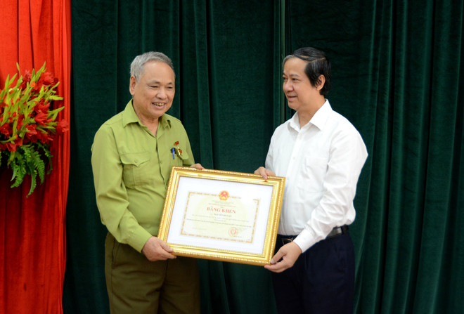 Bộ trưởng Bộ Giáo dục và Đào tạo Nguyễn Kim Sơn tặng bằng khen cho ông Nguyễn Huy Kỳ. (Ảnh: Bộ GD-ĐT) Tặng bằng khen cho thương binh 82 tuổi vẫn dự thi tốt nghiệp THPT ảnh 1