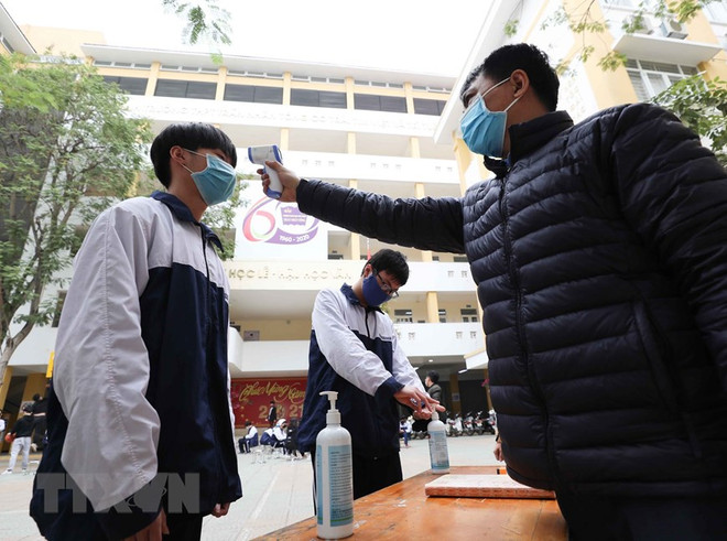 Học sinh Hà Nội được đo thân nhiệt trước khi vào trường. (Ảnh: TTXVN) Khử khuẩn trường học, sẵn sàng đón học sinh trở lại lớp ảnh 1