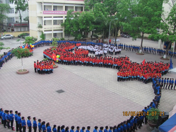 Trong tiếng nhạc bài Dòng máu lạc hồng, học sinh xếp thành hình Tổ quốc giữa một trái tim lớn của màu xanh tình nguyện. (Ảnh: PV/Vietnam+) Học sinh Hà Nội xếp hình Tổ quốc, hướng về biển đảo ảnh 1