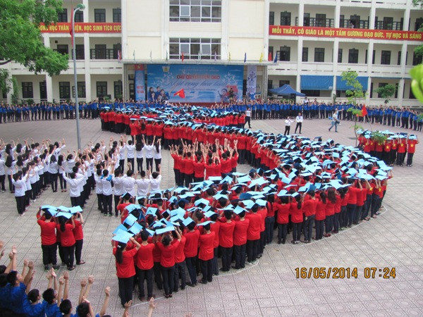 Các em học sinh nâng cao tấm giấy màu xanh, biểu trưng cho khát vọng hòa bình. (Ảnh: PV/Vietnam+) Học sinh Hà Nội xếp hình Tổ quốc, hướng về biển đảo ảnh 4