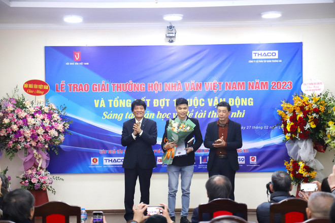 Tác giả Đức Anh (giữa) nhận giải thưởng của Hội Nhà văn Việt Nam. (Ảnh: PV/Vietnam+) ducanh.jpg
