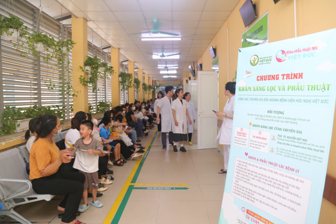 Bà Hoàn (ngồi đầu dãy ghế) và rất nhiều người đã đưa con, cháu đến chờ khám từ sáng sớm. (Ảnh: PV/Vietnam+) IMG_2855.JPG