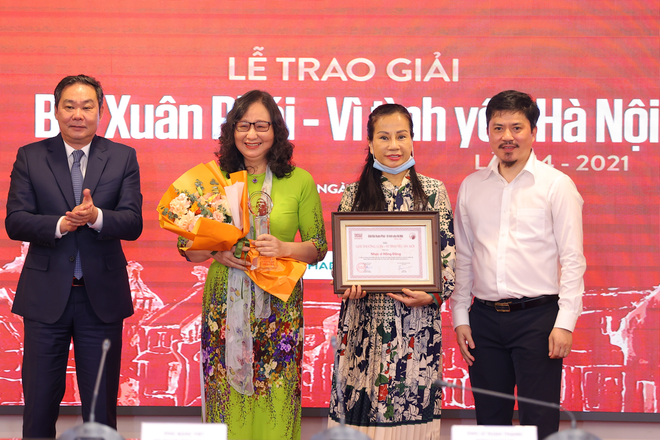 Ông Lê Hồng Sơn (ngoài cùng bên trái), Phó Chủ tịch UBND TP Hà Nội và nhà báo Lê Xuân Thành, Tổng biên tập báo Thể thao và Văn hóa (ngoài cùng bên phải) trao giải thưởng lớn cho gia đình nhạc sỹ. (Ảnh: PV/Vietnam+) Giải thưởng Bùi Xuân Phái vinh danh nhạc sỹ 'Hoa sữa' Hồng Đăng ảnh 1