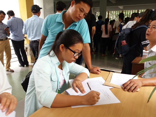 Khi đặt bút viết hồ sơ, thí sinh nên nắm rõ thông tin về học phí. (Ảnh: PM/Vietnam+) Xét tuyển đại học, thí sinh nên tìm hiểu kỹ thông tin về học phí ảnh 3