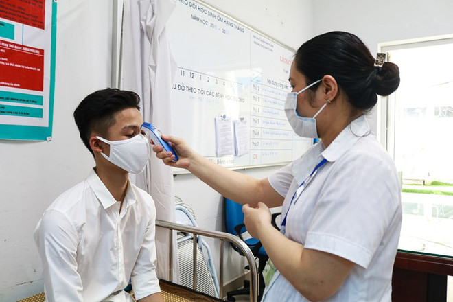 Cán bộ y tế kiểm tra sức khỏe cho thí sinh trong kỳ thi. (Ảnh: Nguyên An/Vietnam+) Bố trí kíp trực y tế tại các điểm thi tốt nghiệp trung học phổ thông ảnh 1