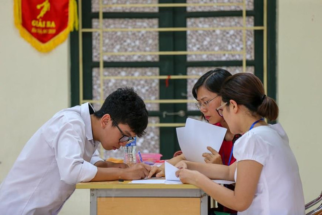 Thí sinh làm thủ tục dự thi Trung học phổ thông quốc gia. (Ảnh: Minh Sơn/Vietnam+) Thứ trưởng Bộ Giáo dục-Đào tạo: Kỳ thi đã diễn ra an toàn, nghiêm túc ảnh 1