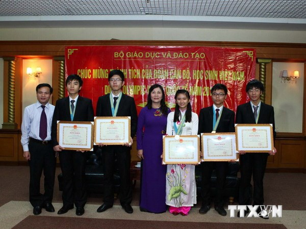 Bà Nguyễn Thị Nghĩa, Thứ trưởng Bộ Giáo dục và Đào tạo trao Bằng khen cho các học sinh đoạt giải tại kỳ thi Olympic Vật lý quốc tế. (Ảnh: Quý Trung/TTXVN) Tuyên dương 50 học sinh xuất sắc kỳ thi Olympic quốc tế và đại học ảnh 1