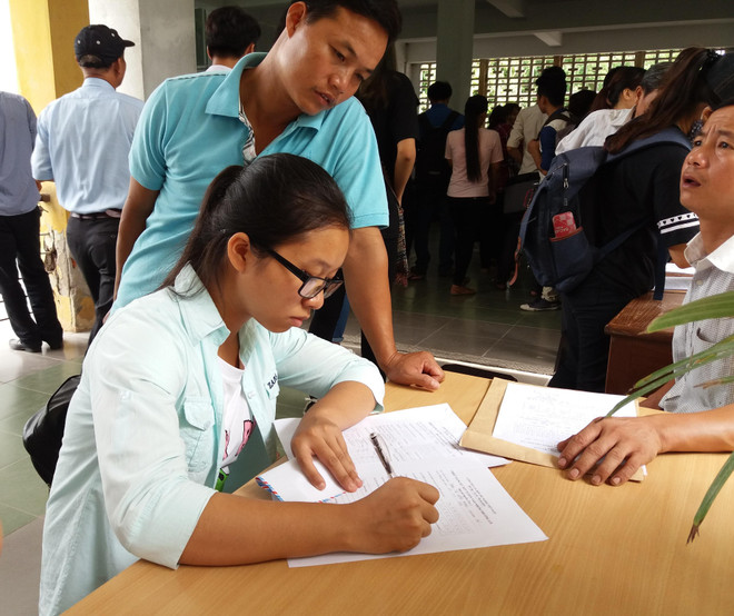 Thí sinh làm hồ sơ xét tuyển đại học. (Ảnh: Phạm Mai/Vietnam+) Trượt đợt một, thí sinh vẫn rộng cửa vào giảng đường đại học ảnh 1