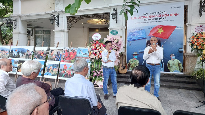 Nhiếp ảnh gia Nguyễn Á (bên phải) chia sẻ tại lễ khai mạc triển lãm. (Ảnh: Minh Thu/Vietnam+) Lực lượng gìn giữ hòa bình Việt Nam ở Nam Sudan qua ống kính Nguyễn Á ảnh 1