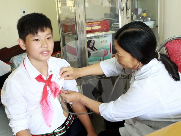 Khám sức khỏe đầu năm học cho học sinh. (Ảnh: Nguyễn Thủy/ TTXVN) Phòng chống dịch bệnh mùa Đông Xuân trong các trường học ảnh 1