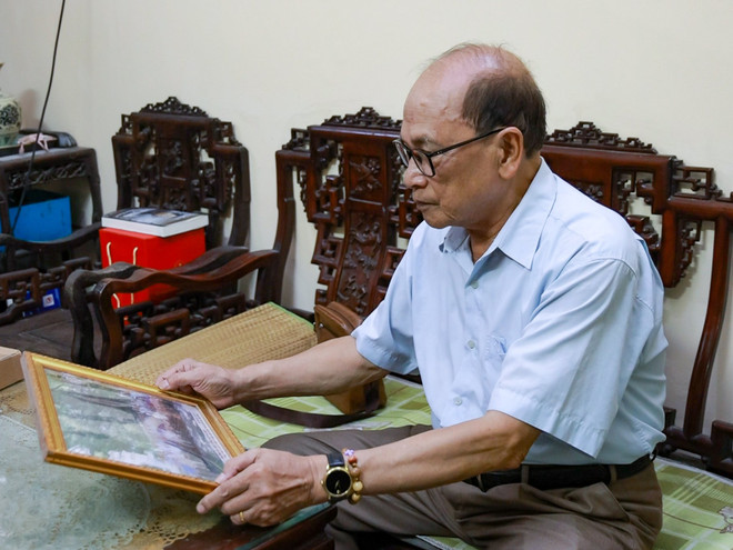 Ông Trần Đình Thảo xem lại ảnh họp lớp cùng Tổng Bí thư Nguyễn Phú Trọng. (Ảnh: PV/Vietnam+) bac Thao 1.jpg