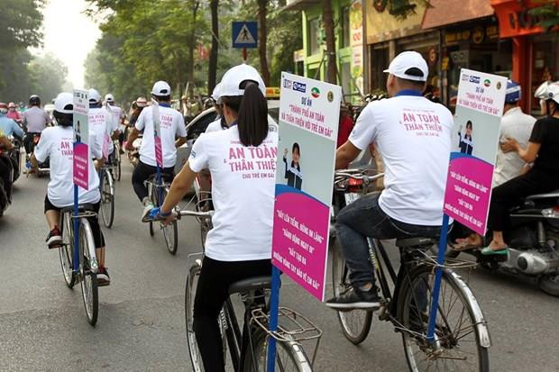 Các em học sinh tham gia đạp xe, phát tờ rơi với thông điệp thành phố an toàn cho trẻ em gái. (Nguồn: Plan International Việt Nam) Đại biểu Quốc hội: Mức độ xâm hại trẻ em ngày càng nghiêm trọng ảnh 1