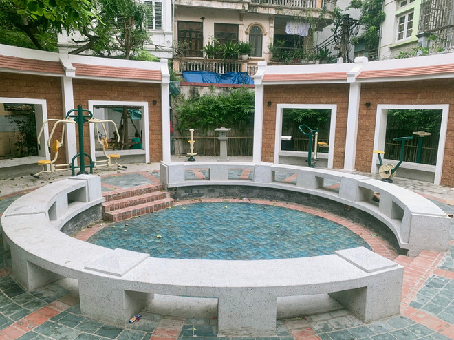 Giếng làng chính là không gian sinh hoạt cộng đồng của người dân. Nay, trong "chiếc áo mới," giếng làng vẫn tiếp tục phụng sự, là nơi trẻ em vui chơi, người lớn tập thể dục, thư giãn, trò chuyện. Lòng giếng được lát gạch men xanh như làn nước mát. Thành giếng được xây cao làm chỗ ngồi nghỉ. (Ảnh: PV/Vietnam+) sangieng5.jpg