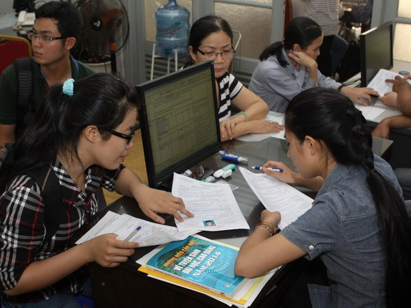 Thí sinh làm hồ sơ xét tuyển đại học. (Ảnh: Phương Vy/TTXVN) Thí sinh, phụ huynh căng thẳng chọn trường xét tuyển đại học ảnh 1