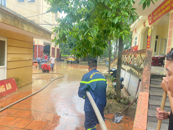Các trường đã có sáng kiến sử dụng vòi phun nước cứu hoả để đẩy bùn đất khỏi sân trường. (Ảnh: PV/Vietnam+) don truong 21.jpg