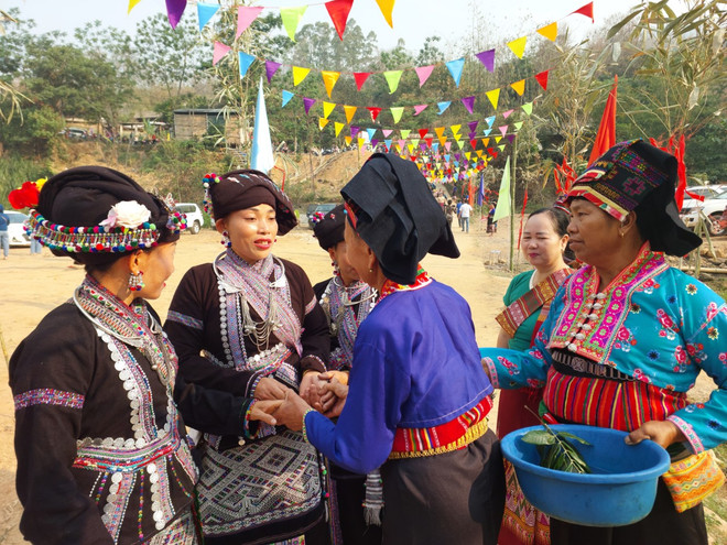 Người Lào ở Lai Châu (áo đen bên trái) và người Lào ở Điện Biên tay bắt mặt mừng trong ngày Tết. (Ảnh: Minh Thu/Vietnam+) vnp_tenuoc2.jpg