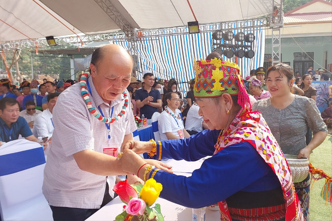 Bà Lường Thị Sao May buộc chỉ cổ tay cho đại biểu tham dự. (Ảnh: Minh Thu/Vietnam+) z5346940505303_a9a7d18927f70af45992aba7ccb8e097.jpg