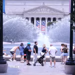 Người dân tránh nắng nóng bên đài phun nước tại khu vực National Mall (Quảng trường Quốc gia) ở thủ đô Washington D.C. (Ảnh: Ngọc Quang/TTXVN)
