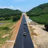 Nhà thầu thi công thảm bêtông nhựa nền đường một tuyến cao tốc. (Ảnh: Khánh Hùng/Vietnam+)